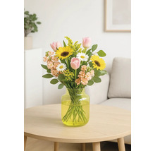 Buchet cu floarea-soarelui, lalele și margarete în vază pe masă