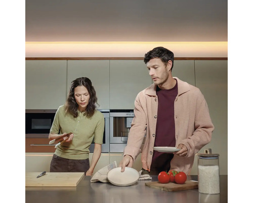 Un cuplu pregătește mâncare într-o bucătărie modernă.