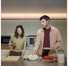 Un cuplu pregătește mâncare într-o bucătărie modernă.