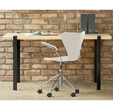 Birou cu masă de scris, scaun de birou și bibliorafturi în fața unui perete de cărămidă