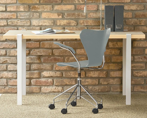 Birou cu scaun de birou în fața unui perete de cărămidă