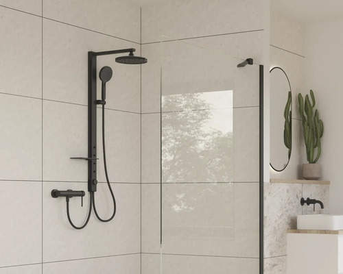 Baie modernă cu armătură de duș neagră și perete de sticlă.