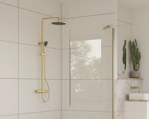 Baie modernă cu baterie de duș și perete de sticlă