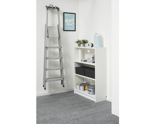 Scară din aluminiu argintiu pe un suport de perete într-o cameră luminoasă și organizată, lângă un raft alb.