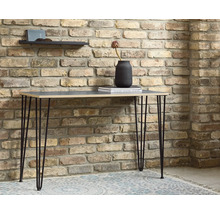 Masa cu picioare tip ac de păr în fața unui zid de cărămidă