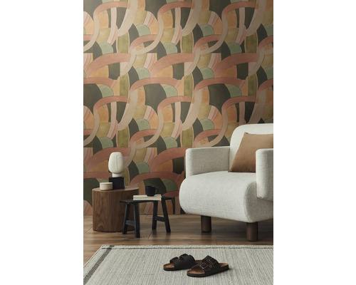 Cameră de zi cu tapet cu model, fotoliu și decorațiuni pe măsuțe laterale