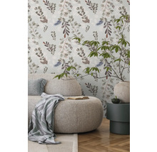 Cameră de zi luminoasă cu canapea, măsuță laterală și tapet floral pentru o atmosferă prietenoasă