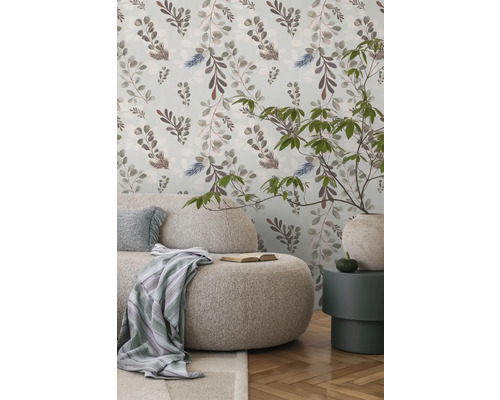 Cameră de zi luminoasă cu canapea, măsuță laterală și tapet floral pentru o atmosferă prietenoasă