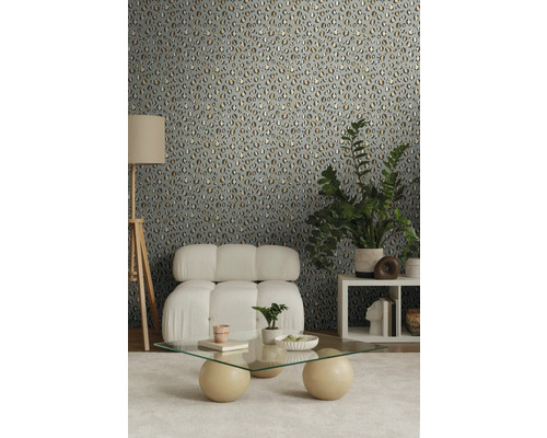 Cameră decorată cu un perete cu tapet cu model animalier, un fotoliu, o măsuță de cafea și o lampă de podea.