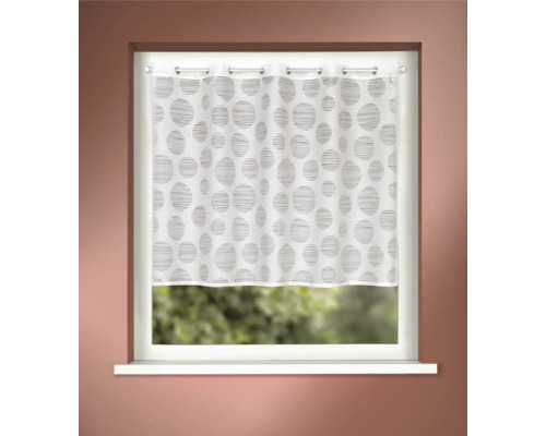 Perdea cu design circular în fața unei ferestre