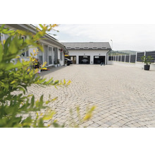 Alee pavată cu piatră cubică în fața unei case cu garaj