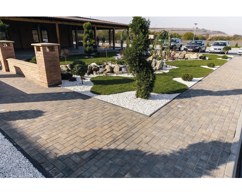 Exterior cu pavaj, pietriș și zone verzi.