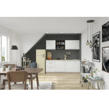 Bucătărie luminoasă cu zonă de luat masa, dotată cu dulapuri de bucătărie, masă de sufragerie, scaune și un frigider retro.