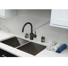 Chiuvetă de bucătărie cu robinet și elemente decorative pe un blat de lucru.