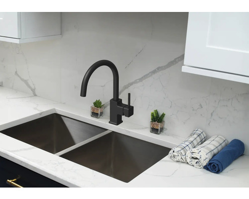 Chiuvetă de bucătărie cu robinet și elemente decorative pe un blat de lucru.