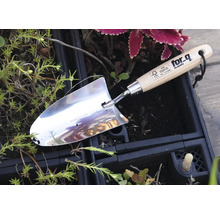 Plantator din oțel inoxidabil cu mâner din lemn într-un strat de flori