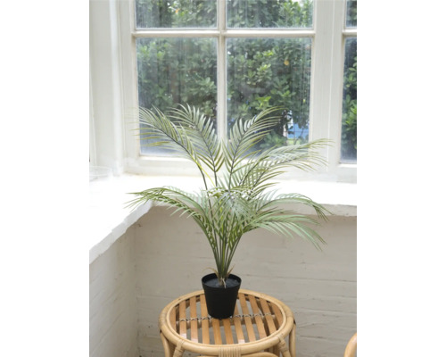 Palmier areca artificial în ghiveci pe o masă de ratan în fața unei ferestre