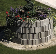 Jardinieră înălțată din pietre de beton cu plante în grădină