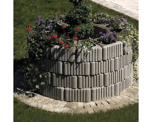 Jardinieră înălțată din pietre de beton cu plante în grădină