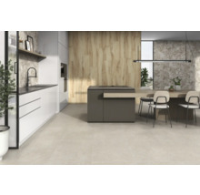 Spațiu de bucătărie luminos și modern, cu insulă de bucătărie, zonă de luat masa și podea cu gresie.