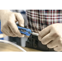 Persoană care dezizolează un cablu cu un clește de dezizolat