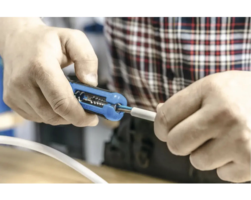 Persoană care dezizolează un cablu cu un clește de dezizolat