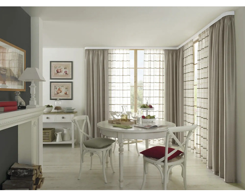 Sufragerie cu masă rotundă, scaune și perdele pe o tijă de perdea