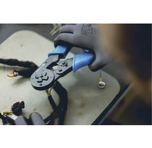 Un clește de sertizat în utilizare cu cabluri și un terminal tubular.