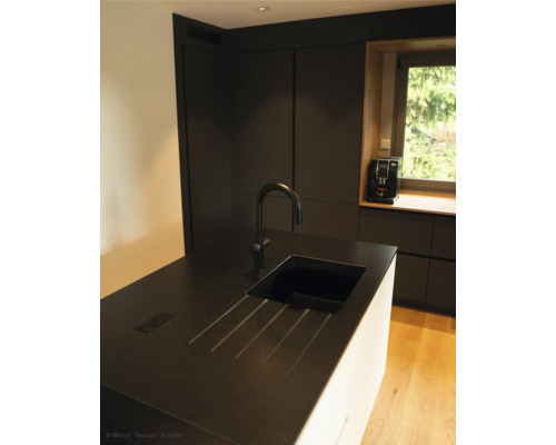 Scenă de bucătărie cu chiuvetă, robinet și aparate de bucătărie în fața ferestrei