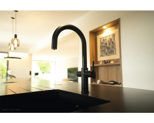 Baterie de bucătărie neagră pe o chiuvetă într-o bucătărie modernă.