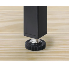 Prim-plan cu un picior de masă negru cu picior reglabil pe o podea de lemn.