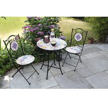 Scenă de grădină cu o masă mică și două scaune cu model mozaic pe o terasă.