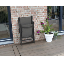 Scaun de grădină pliat lângă un ghiveci de flori pe o terasă