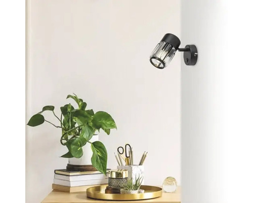 Birou cu plantă de interior și lampă de perete neagră