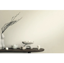 Scenă decorativă cu vază, ramuri, bol și figurine ceramice pe o masă