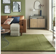 Cameră de zi cu canapea de piele, dulap din lemn și covor dreptunghiular în verde