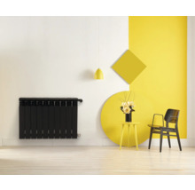 Imagine cu calorifer panou, măsuță laterală cu flori, scaun și forme geometrice pe perete