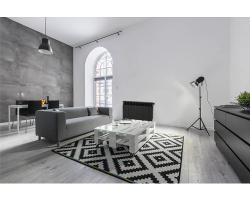 Cameră de zi luminoasă cu canapea, masă, covor și zonă de luat masa