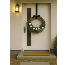 Coroniță decorativă de ușă cu motive de Crăciun pe o ușă de intrare