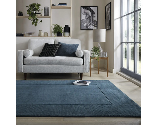 Living cu covor albastru, canapea și decorațiuni