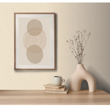 Imagine decorativă cu model circular în ramă de lemn, pe o masă cu o vază decorativă și cărți