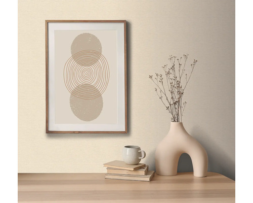 Imagine decorativă cu model circular în ramă de lemn, pe o masă cu o vază decorativă și cărți