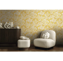 Cameră de zi cu tapet cu motive galbene, fotoliu și comodă