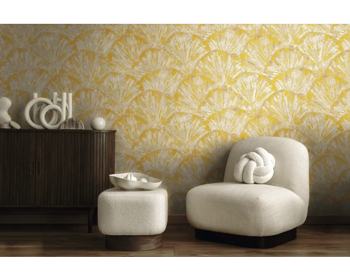 Cameră de zi cu tapet cu motive galbene, fotoliu și comodă