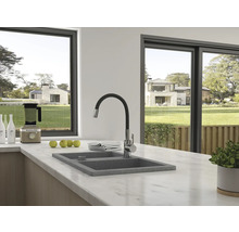 Scenă de bucătărie cu chiuvetă, baterie și aparate de bucătărie în fața unei ferestre