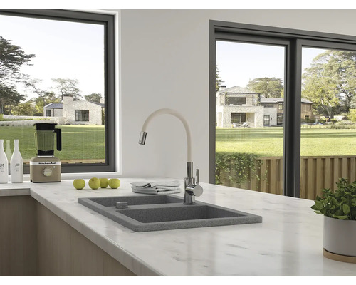 Chiuvetă de bucătărie cu robinet pe un blat de marmură în fața unei ferestre