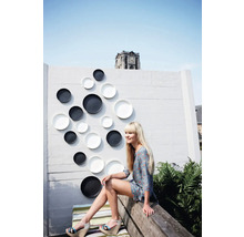 Perete decorativ cu farfurii ornamentale în exterior cu o femeie așezată pe o bancă