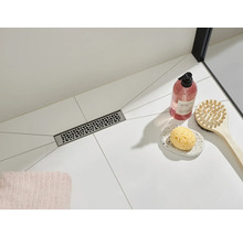 Podea de duș cu rigolă de scurgere și accesorii de baie pe gresie