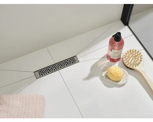 Podea de duș cu rigolă de scurgere și accesorii de baie pe gresie