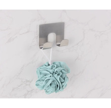 Burete de duș atârnă pe un cârlig de perete din oțel inoxidabil